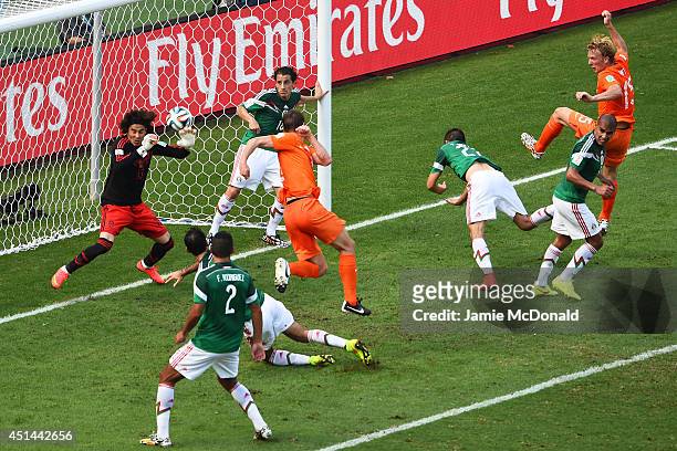 Goalkeeper Guillermo Ochoa of Mexico makes a save after a shot at goal by Stefan de Vrij of the Netherlands during the 2014 FIFA World Cup Brazil...