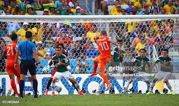 Wesley Sneijder of the Netherlands shoots and scores his team's first goal past Guillermo Ochoa of Mexico during the 2014 FIFA World Cup Brazil Round...
