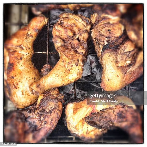 Jerk chicken is cooked on the Likes Tropical food stall at the Glastonbury Festival on June 29, 2014 in Glastonbury, England. Gates opened on...