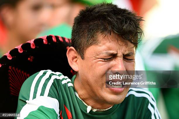 Dejected Mexico fan reacts after being defeated by the Netherlands 2-1 during the 2014 FIFA World Cup Brazil Round of 16 match between Netherlands...