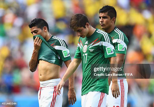 Javier Aquino and Isaac Brizuela and Miguel Angel Ponce of Mexico walk off the pitch after the 1-2 defeat in the 2014 FIFA World Cup Brazil Round of...