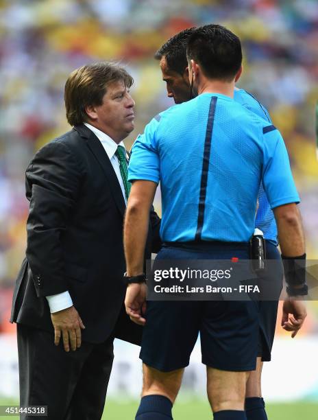 Head coach Miguel Herrera of Mexico speaks with Referee Pedro Proenca during the 2014 FIFA World Cup Brazil Round of 16 match between Netherlands and...