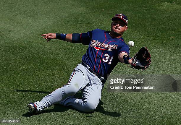 Oswaldo Arcia of the Minnesota Twins makes a sliding catch for the out on a fly ball hit by Adrian Beltre of the Texas Rangers in the bottom of the...