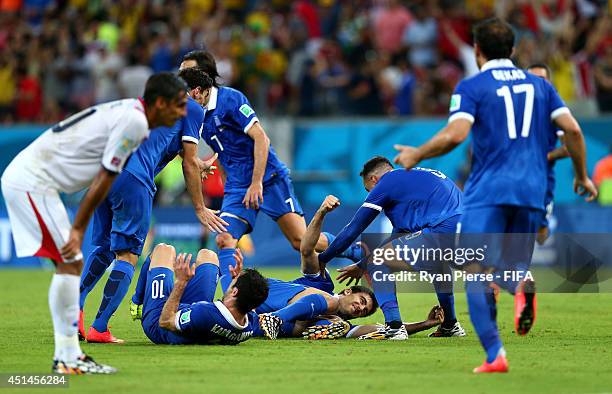 Sokratis Papastathopoulos of Greece celebrates scoring his team's first goal with his teammates during the 2014 FIFA World Cup Brazil Round of 16...