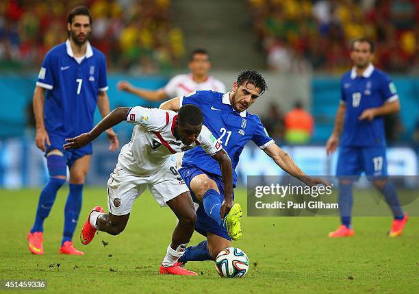 Joel Campbell of Costa Rica and Konstantinos Katsouranis of Greece compete for the ball during the 2014 FIFA World Cup Brazil Round of 16 match...