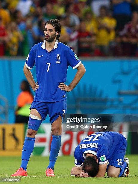 Giorgos Samaras and Vasilis Torosidis of Greece look dejected after being defeated by Costa Rica in a penalty shootout during the 2014 FIFA World Cup...