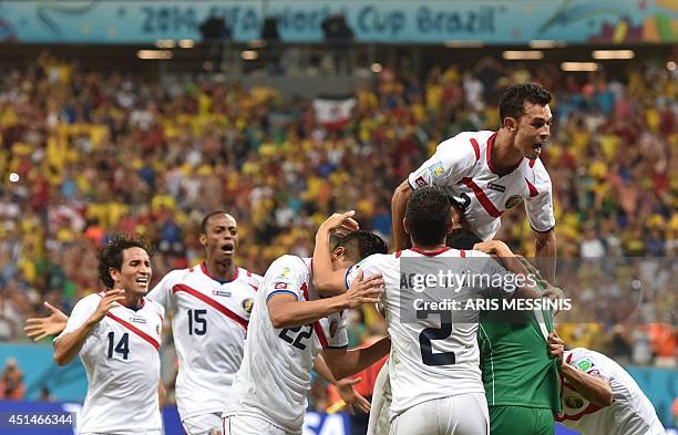 Costa Rica's footballers celebrate winning the Round of 16 football match between Costa Rica and Greece at Pernambuco Arena in Recife during the 2014...