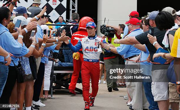 Takuma Sato of Japan, driver of the ABC Supply A.J. Foyt Racing Dallara Honda, walks to the track during the Verizon IndyCar Series Shell and...