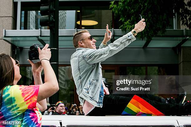 Macklemore rides on the roof of his Cadillac during the 40th annual Seattle Pride Parade on June 29, 2014 in Seattle, Washington.