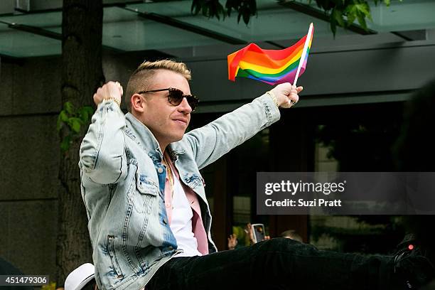 Macklemore rides on the roof of his Cadillac during the 40th annual Seattle Pride Parade on June 29, 2014 in Seattle, Washington.