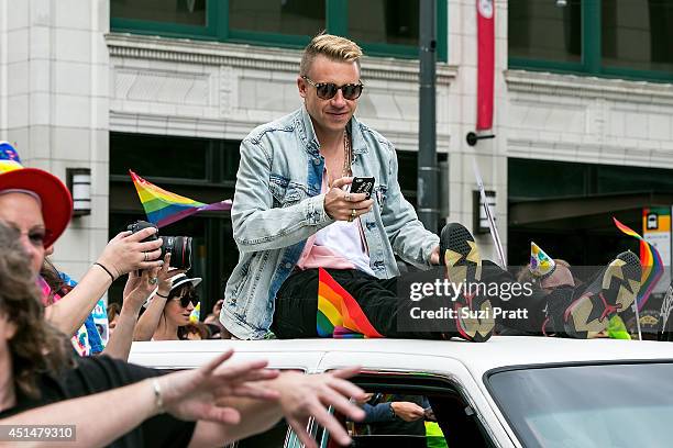Macklemore rides on the roof of his Cadillac during the 40th annual Seattle Pride Parade on June 29, 2014 in Seattle, Washington.