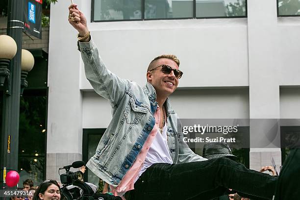 Macklemore rides on the roof of his Cadillac during the 40th annual Seattle Pride Parade on June 29, 2014 in Seattle, Washington.