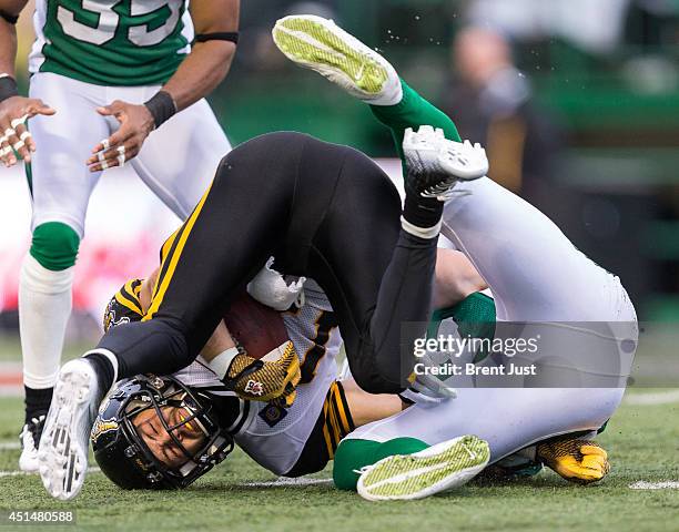 Luke Tasker of the Hamilton Tiger-Cats is tackled during in a game between the Saskatchewan Roughriders and Hamilton Tiger-Cats week one of the 2014...