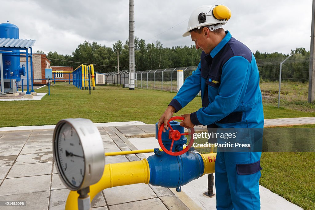 A worker turns a valve at a boosting compressor station ''...