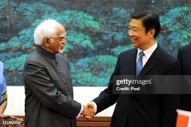 Chinese Vice President Li Yuanchao shakes hands with Indian Vice President Shri Mohammad Hamid Ansari as they attend a signing ceremony at the Great...