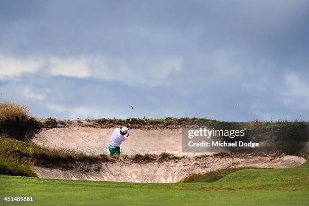Graeme McDowell of Ireland chips out of a bunker during day three of the World Cup of Golf at Royal Melbourne Golf Course on November 23, 2013 in...