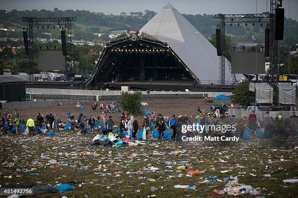 Litter pickers clear the rubbish left in front of the main Pyramid Stage at Worthy Farm in Pilton on June 30, 2014 near Glastonbury, England....