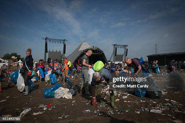 Litter pickers clear the rubbish left in front of the main Pyramid Stage at Worthy Farm in Pilton on June 30, 2014 near Glastonbury, England....