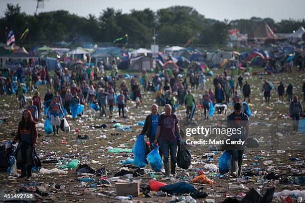 Litter pickers clear the rubbish left in front of the main Pyramid Stage at Worthy Farm in Pilton on June 30, 2014 near Glastonbury, England....