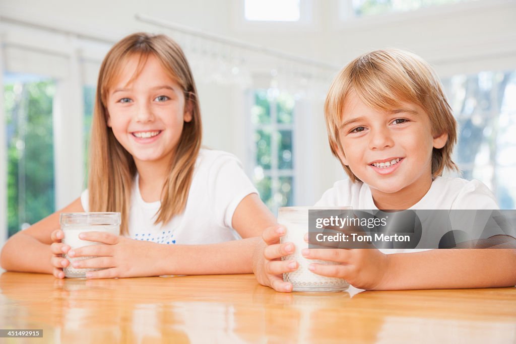 Young boy y Chica joven en cocina con gafas de leche