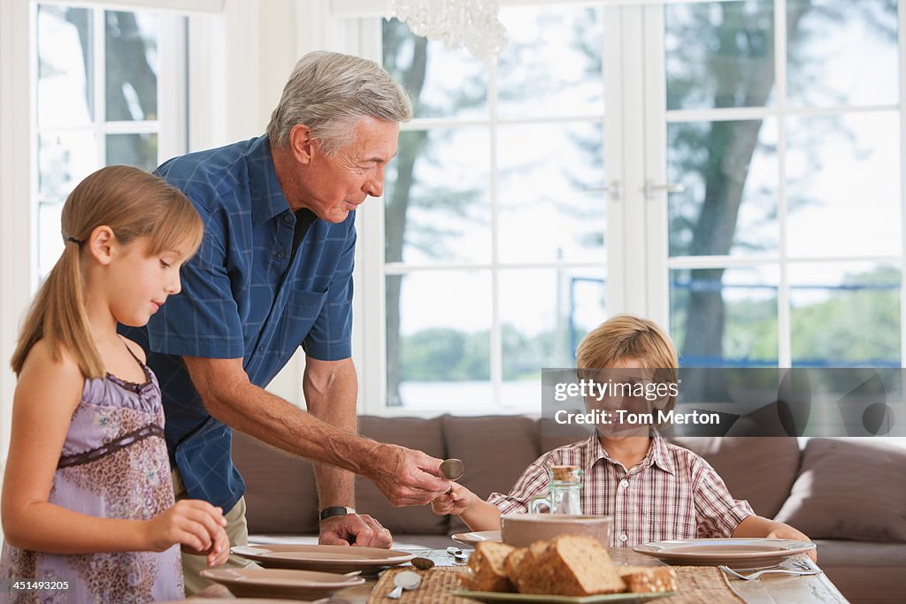 Mann und zwei Kinder im Esszimmer den Tisch