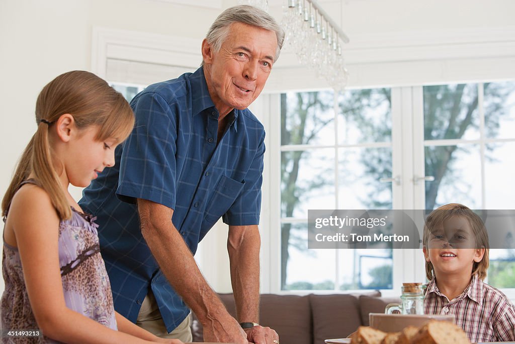 Man and two kids in dining room setting table