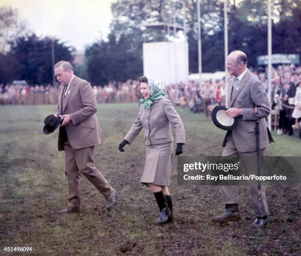 Queen Elizabeth II laughing as she walks through mud in her Wellington boots during the Royal Windsor Horse Show in Berkshire on 11th May 1968....