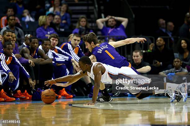 Goran Dragic of the Phoenix Suns and Kemba Walker of the Charlotte Bobcats dive after a loose ball during their game at Time Warner Cable Arena on...