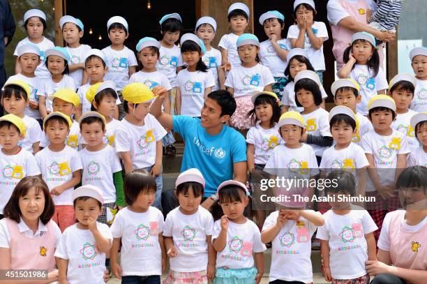 Football player Makoto Hasebe poses for photographs with pupils at Asahi Kindergarten during his visit to the tsunami devastated Minamisanriku on...