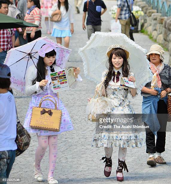 The event participants in Lolita fashion costumes walk along the canal on June 29, 2014 in Otaru, Hokkaido, Japan. About 90 girls and young women...