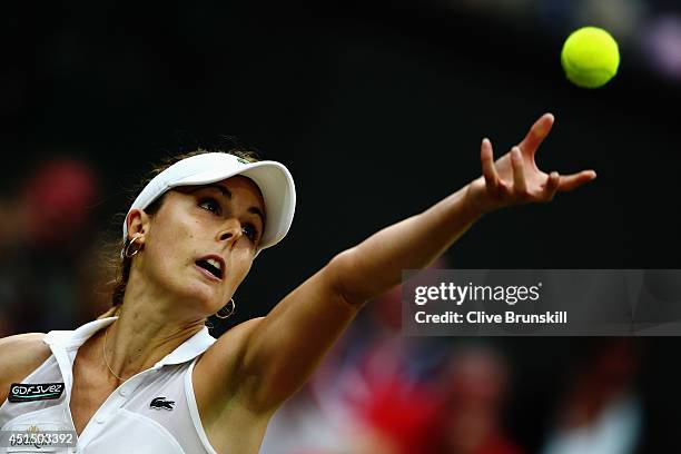 Alize Cornet of France serves during her Ladies' Singles fourth round match against Eugenie Bouchard of Canada on day seven of the Wimbledon Lawn...