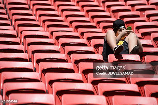 Football fan uses his mobile phone prior to a Round of 16 football match between France and Nigeria at Mane Garrincha National Stadium in Brasilia...