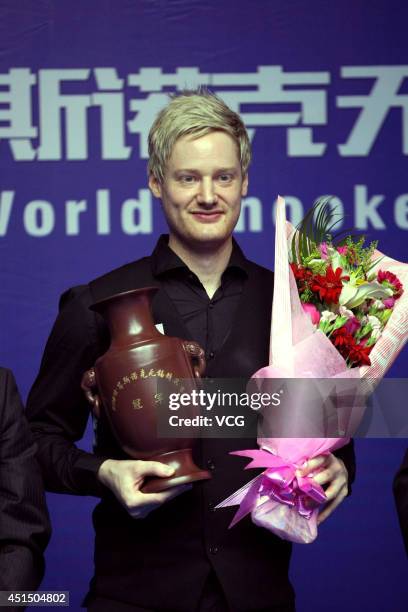 Neil Robertson of Australia poses with the trophy after winning the final match against Joe Perry of England on day seven of the 2014 World Snooker...