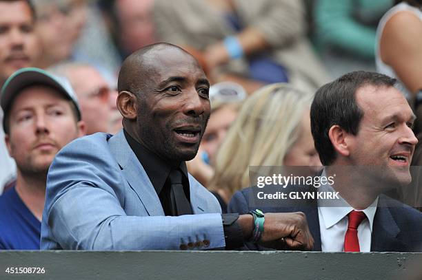 British former boxing champion Johnny Nelson watches the men's singles fourth round match between Britain's Andy Murray and South Africa's Kevin...
