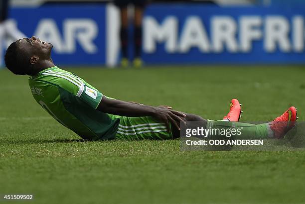 Nigeria's forward Emmanuel Emenike sits on the pitch during a Round of 16 football match between France and Nigeria at Mane Garrincha National...