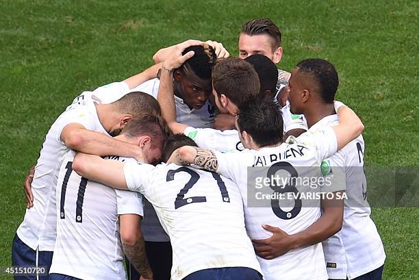 France's midfielder Paul Pogba celebrates with team-mates after scoring their first goal during a Round of 16 football match between France and...