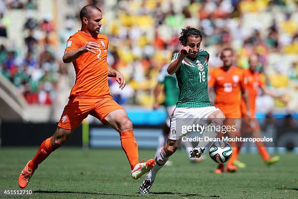 Andres Guardado of Mexico controls the ball against Ron Vlaar of the Netherlands during the 2014 FIFA World Cup Brazil Round of 16 match between...