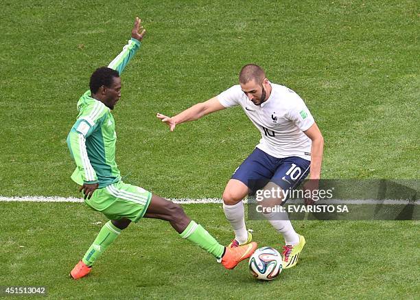 Nigeria's defender Juwon Oshaniwa vies with France's forward Karim Benzema during a Round of 16 football match between France and Nigeria at Mane...