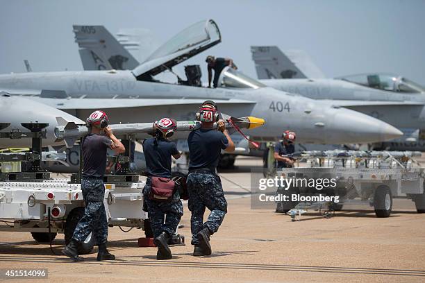 Navy ordnancemen from the Strike Fighter Squadron "Wildcats" de-arm an F/A-18C aircraft on the flight line at the Naval Air Station Oceana in...