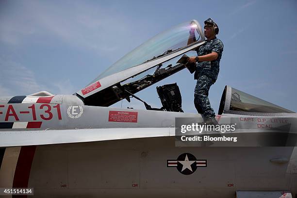Navy petty officer 3rd class Jefferson Metzen performs maintenance on an F/A-18C aircraft after flight at the Naval Air Station Oceana in Virginia...