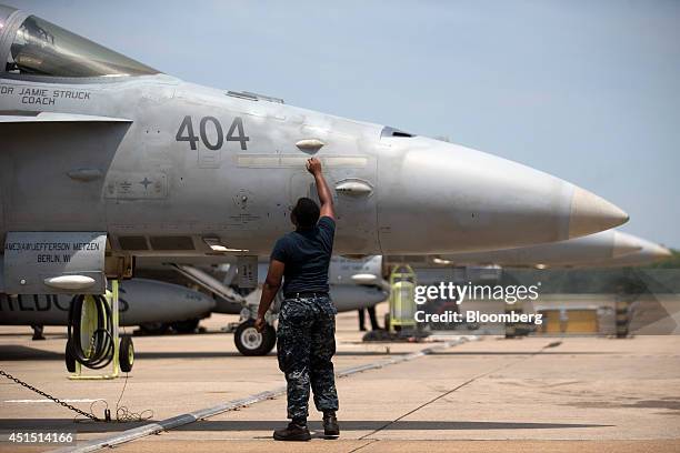 Member of the U.S. Navy Strike Fighter Squadron "Wildcats" performs maintenance on an F/A-18C aircraft after a flight at the Naval Air Station Oceana...