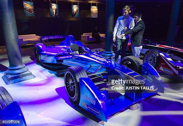 People look at a racing car on a stand at the Global Launch of the all-electric FIA Formula E Championship in London on June 30, 2014. AFP...