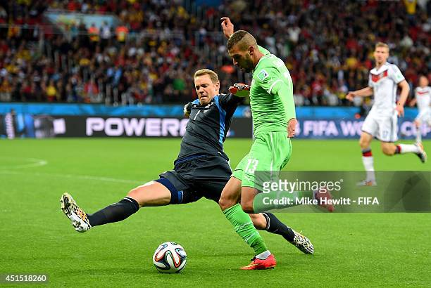 Islam Slimani of Algeria tries to shoot at goal while Manuel Neuer of Germany tackles to block outside the penalty area during the 2014 FIFA World...