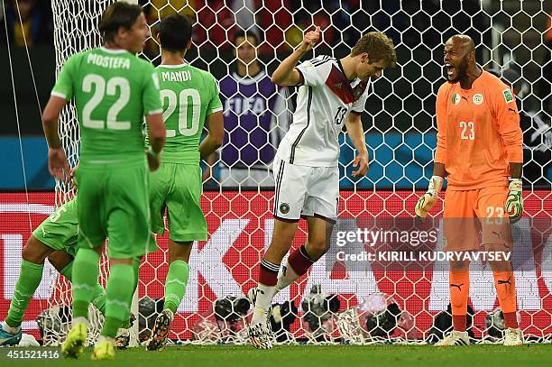 Germany's forward Thomas Mueller and Algeria's goalkeeper Rais Mbohli gesture to their teams during a Round of 16 football match between Germany and...