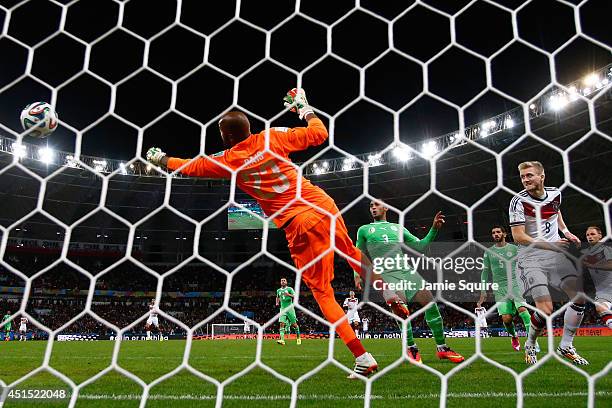 Andre Schuerrle of Germany scores his team's first goal past Rais M'Bolhi of Algeria in extra time during the 2014 FIFA World Cup Brazil Round of 16...