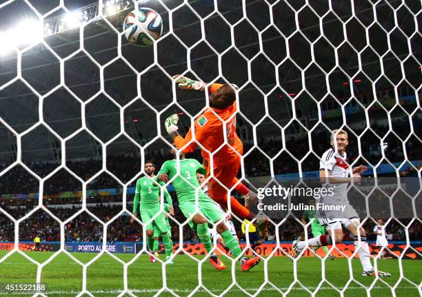 Andre Schuerrle of Germany scores his team's first goal past goalkeeper Rais M'Bolhi of Algeria in extra time during the 2014 FIFA World Cup Brazil...