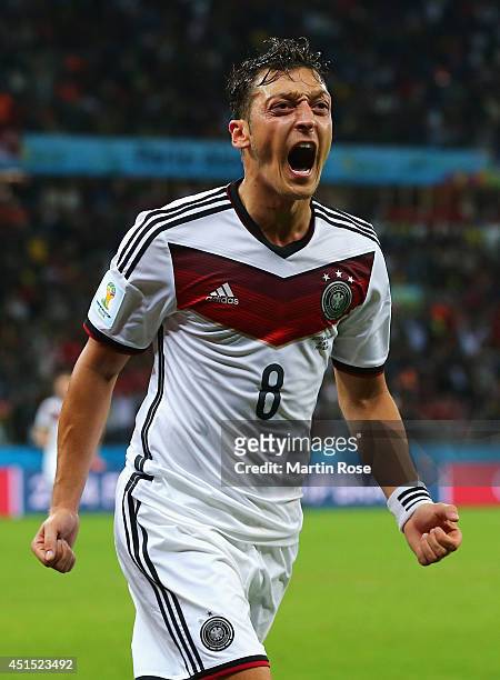Mesut Oezil of Germany celebrates scoring his team's second goal in extra time during the 2014 FIFA World Cup Brazil Round of 16 match between...