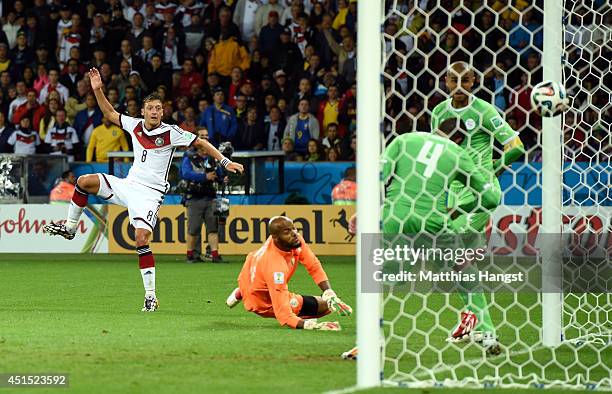Mesut Oezil of Germany scores his team's second goal past Rais M'Bolhi of Algeria during the 2014 FIFA World Cup Brazil Round of 16 match between...
