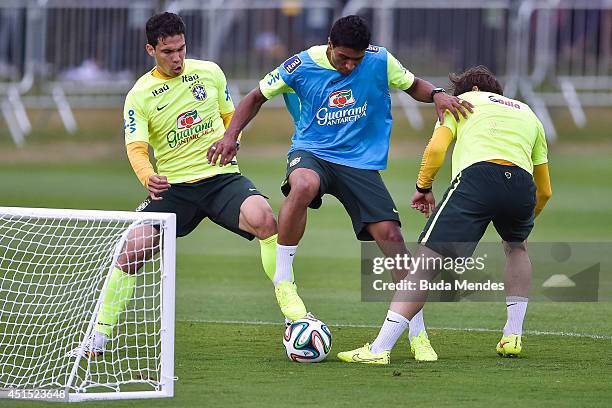 Paulinho with a Hernane and Maxwell take part during a training session of the Brazilian national football team at the squad's Granja Comary training...
