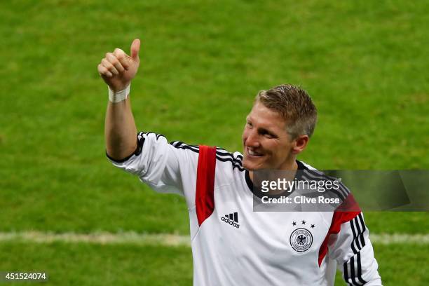 Bastian Schweinsteiger of Germany acknowledges the fans after defeating Algeria 2-1 during the 2014 FIFA World Cup Brazil Round of 16 match between...